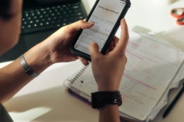 person-using-a-smartphone-over-a-notebook.jpg Person using a smartphone over a notebook